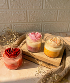 Trio of marbled glass candles in purple, yellow, and red with heart shaped flower made up of soy wax.