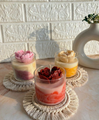 Trio of marbled glass candles in purple, yellow, and red with heart shaped flower made up of soy wax.