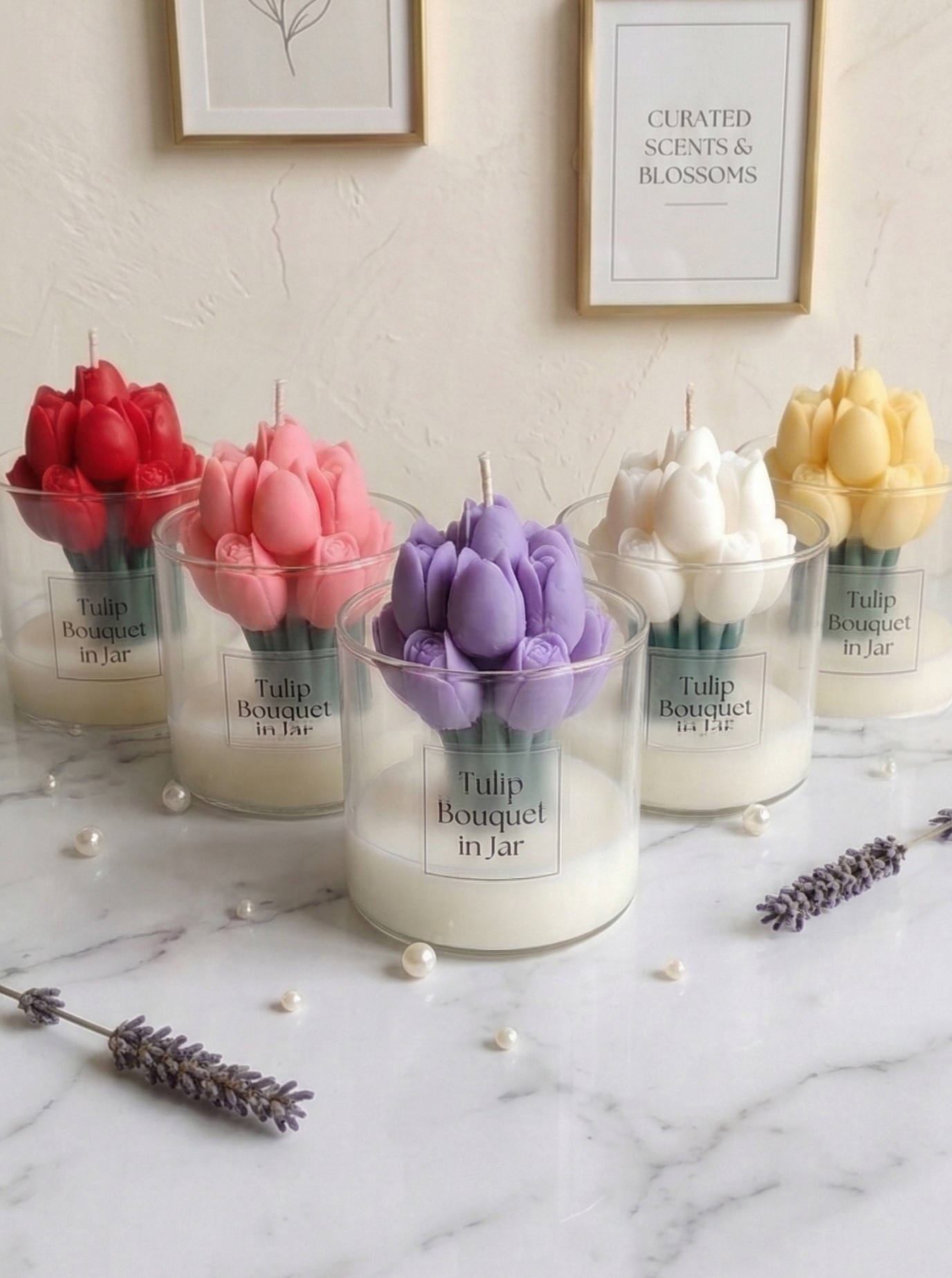 Five Tulip Bouquet in Jar candles in red, pink, purple, white, and yellow shades arranged on a marble surface with pearls.
